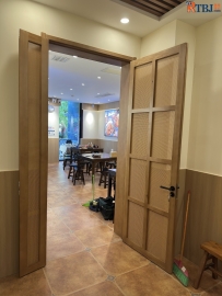 商业场所餐厅的藤编室内对开子母木门+双包套+90度出人头地工艺安装完工图